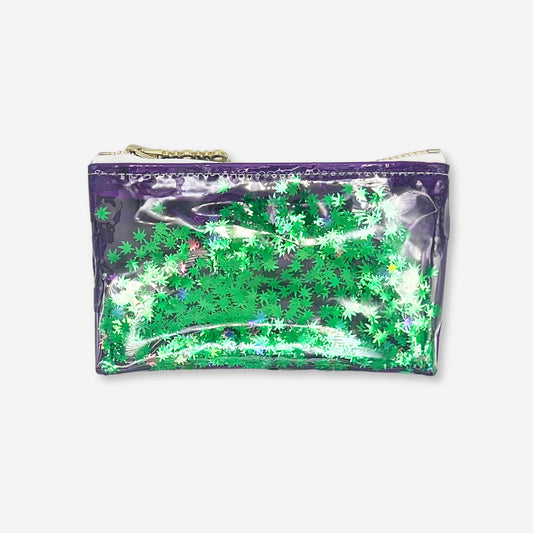 A bold clear purple vinyl keychain clutch filled with floating green cannabis leaf confetti. Designed by Kush Kards in collaboration with Julie Mollo, this stylish mini stash bag features a silver zipper and is perfect for carrying rolling papers, lighters, and cash