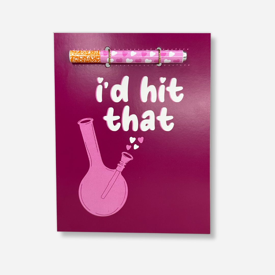 A cheeky greeting card with a deep plum background, featuring the phrase 'I'd hit that' in casual white script above an illustration of a bong, complete with playful heart accents, evoking a sense of humor and camaraderie.