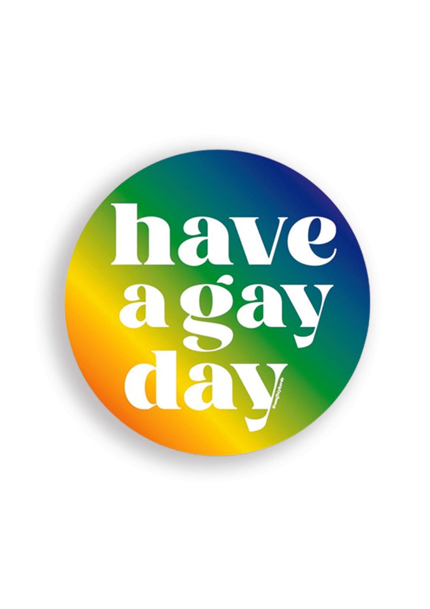 Matte Vinyl Circle Sticker with rainbow ombre background with bold white lettering that reads "Have a Gay Day"