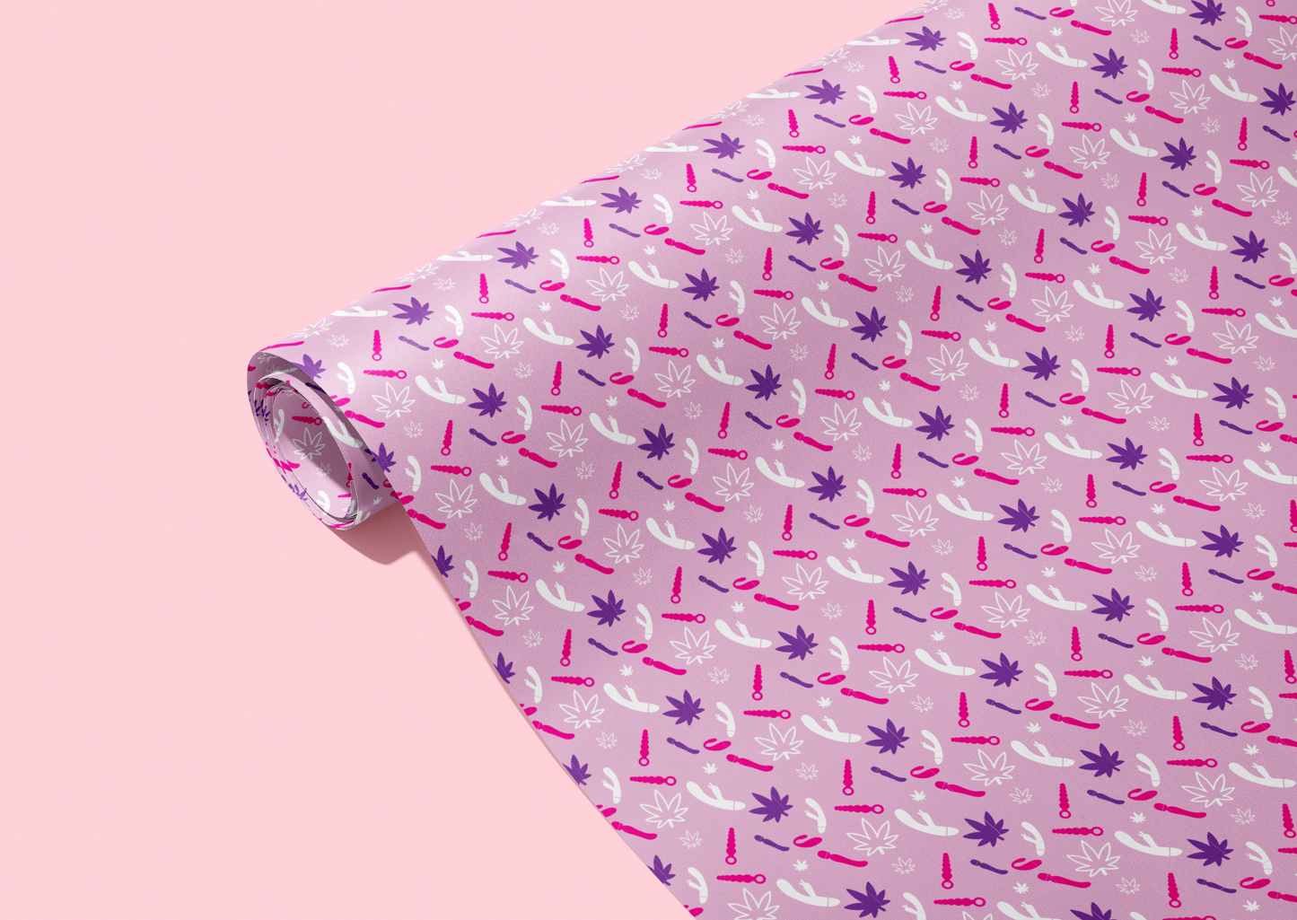 Wrapping paper rolled up with step and repeat pattern of pot leaves and vibrators. Purple background with dark purple, magenta, and white print.